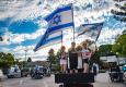 גפן, ישי ולין מעין השופט מניפים בגאווה את דגלי ישראל במחאת הקלנועיות השבוע. צילום: אלכס פינדלינד