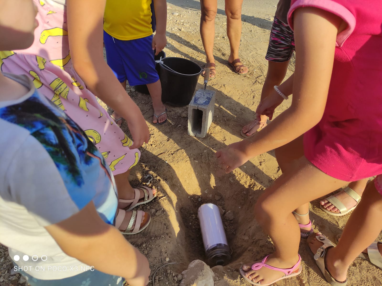 ילדי המרכזון בעין השלושה מטמינים קפסולה עם ברכות וציורים פרי ידיהם בהנחת אבן הפינה