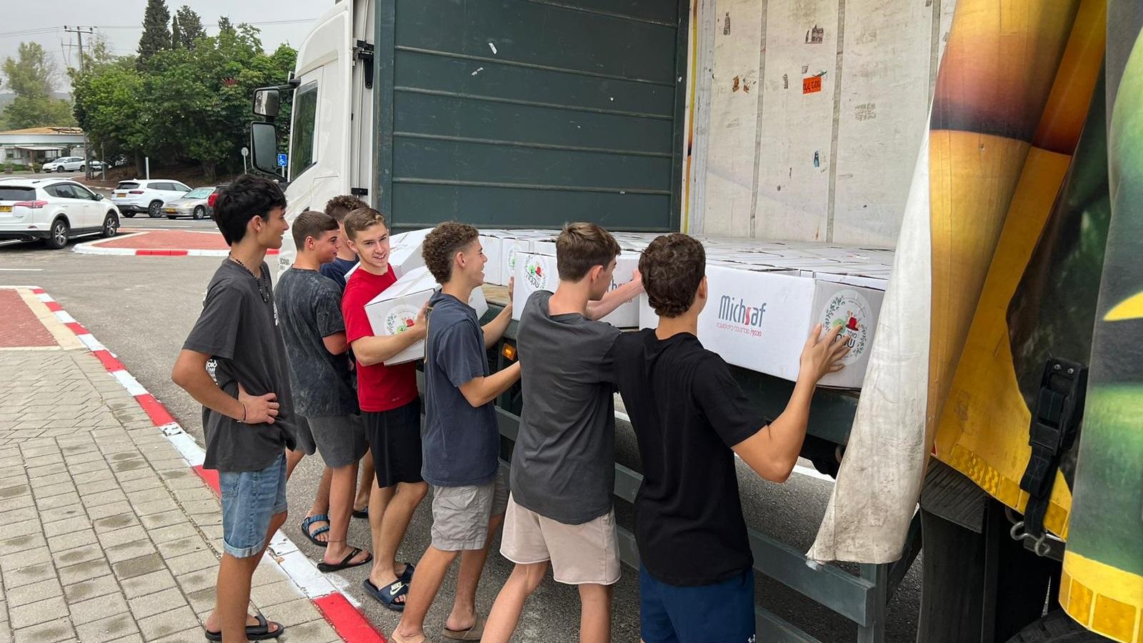 נערים מתיכון שקמה-דרכא מעמיסים ארגזי מזון לתרומה למשאית של גרנות