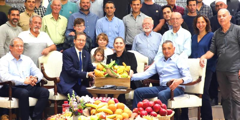 תמונה קבוצתית של החקלאים עם הנשיא ורעייתו יחד עם תוצרת הארץ. צילום: ששון תירם