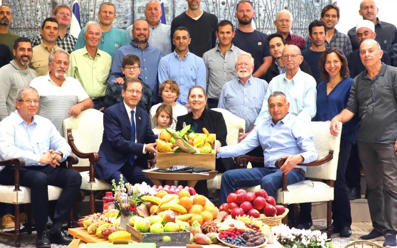 תמונה קבוצתית של החקלאים עם הנשיא ורעייתו יחד עם תוצרת הארץ. צילום: ששון תירם
